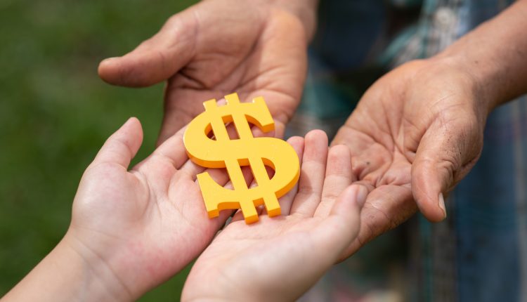 Trabalho voluntário: duas pessoas com as mãos estendidas com as palmas para cima, com um cifrão amarelo em cima